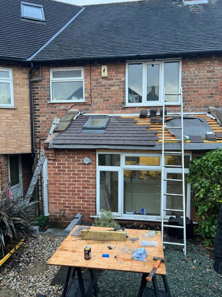 This is a photo of a roof extension that is having new roof tiles installed. This is a photo taken from the roof ridge looking down a tiled pitched roof on to a flat roof. Works carried out by Warlingham Roofing Repairs