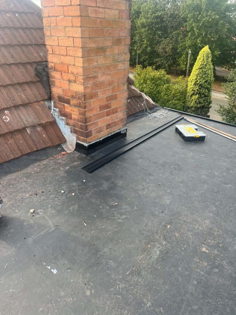 This is a photo of a flat roof which has just been repaired, there is also a chimney stack and some leadwork has also been dressed. Works carried out by Warlingham Roofing Repairs