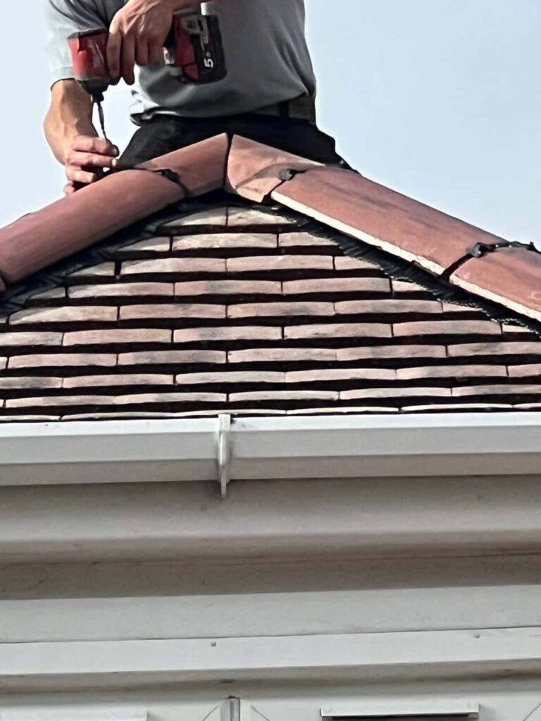 This is a photo of one of the operatives of Warlingham Roofing Repairs installing new ridge tiles